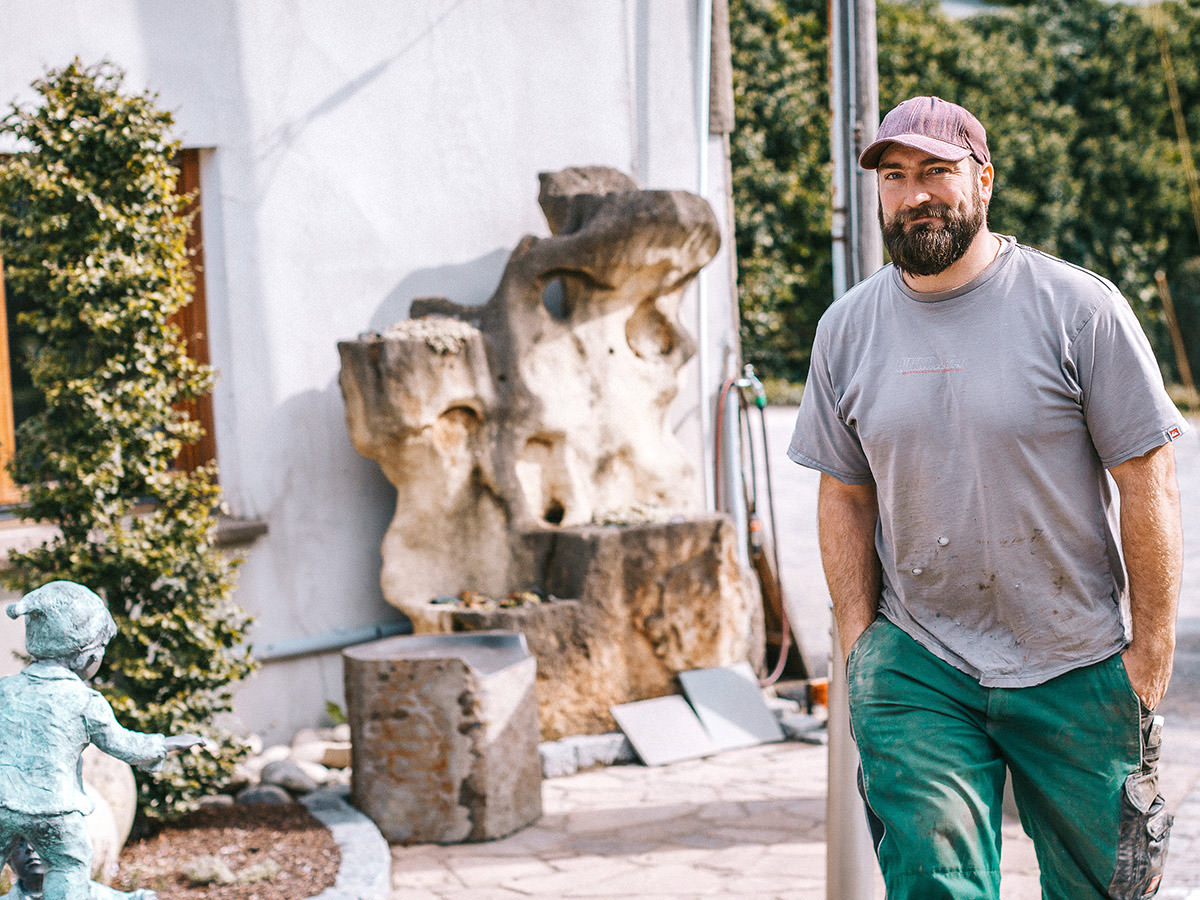 Ein Mitarbeiter von BGS GmbH geht an der Ausstellung vorbei und lacht in die Kamera. BGS GmbH