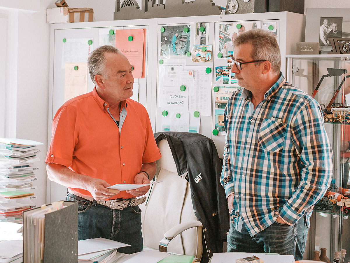 Der Geschäftsführer der Firma BGS GmbH und ein Angestellter unterhalten sich im Büro - BGS GmbH