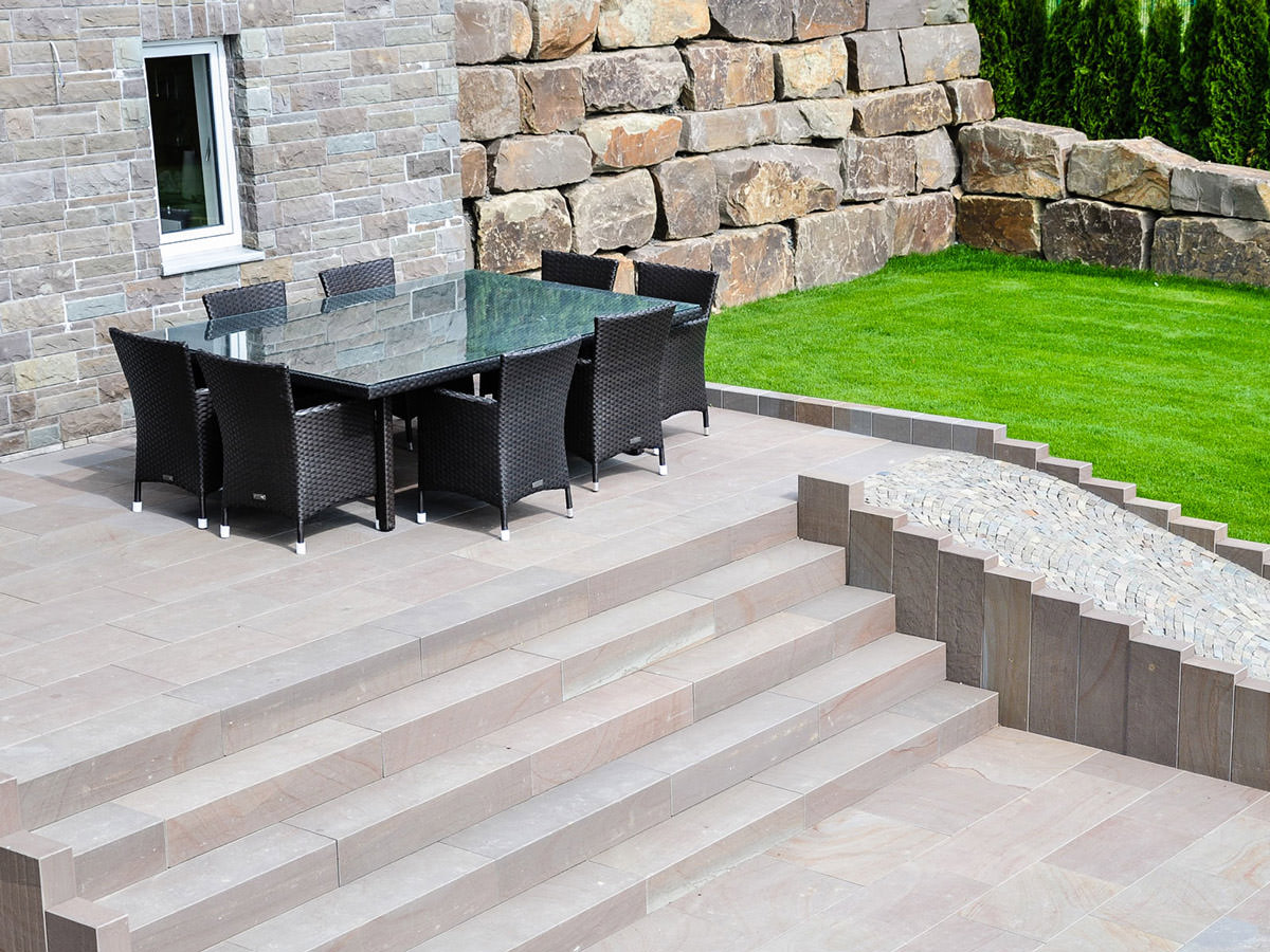 Ein Garten mit einer Findlingsmauer, hochwertigen Stufenanlagen und Pflaster aus Grauwacke. BGS GmbH 